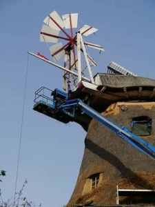 Schadstellen an der Außenhülle werden mit neuem Reet ausgebessert.